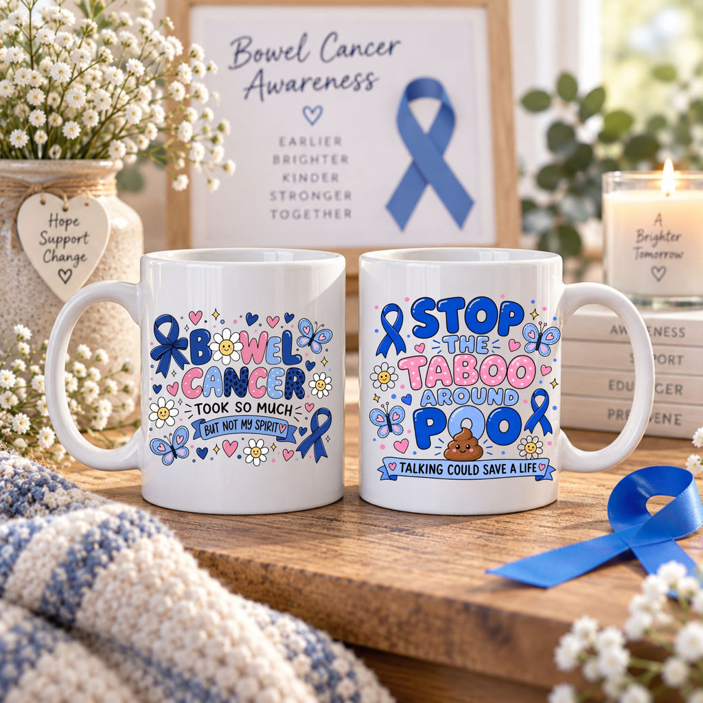 Two white ceramic mugs with colorful Bow Cancer Awareness-themed designs, displayed on a wooden surface with flowers, a candle, and a framed awareness sign in the background.
