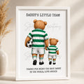 Framed artwork with two teddy bears in green and white striped soccer uniforms, holding a soccer ball, on a beige background.