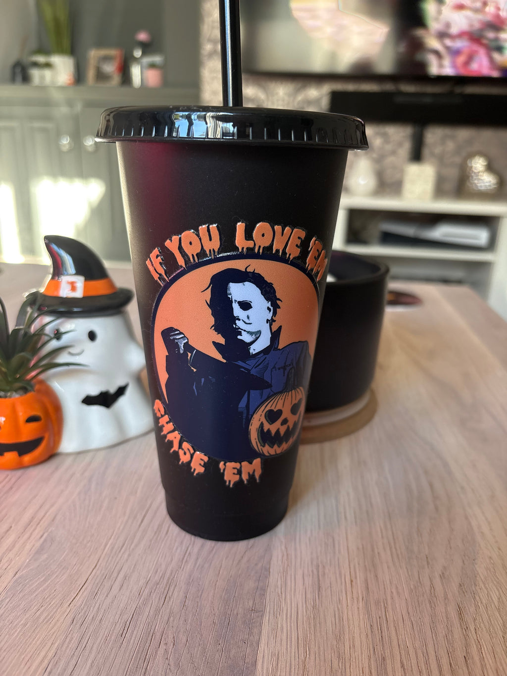 Black 24oz scary movie cold cup with lid and straw, orange “If you love ’em, chase ’em” lettering and masked slasher design