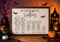 A framed Halloween-themed print reading 'HALLOWEEN WITH THE Walkers' with black line drawings of five children dressed as mummies and names below, displayed on a wooden surface with pumpkins, lanterns, and a haunted-house backdrop.