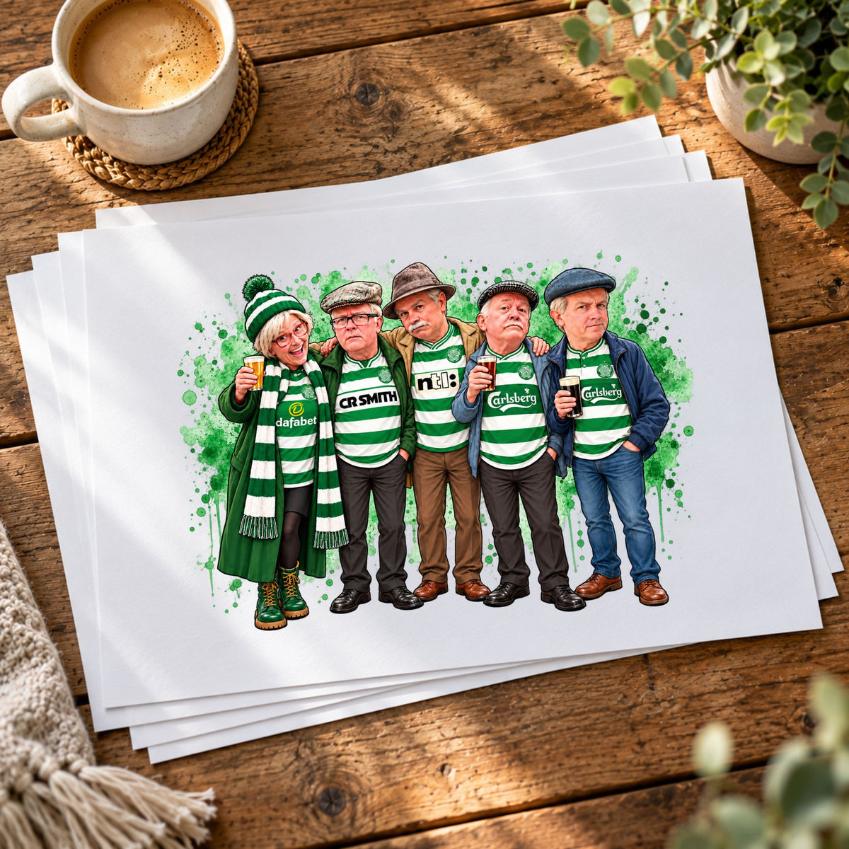 A stack of custom caricature art prints featuring five people in green and white striped shirts and scarves, styled on a rustic wooden table with a coffee cup and plants.