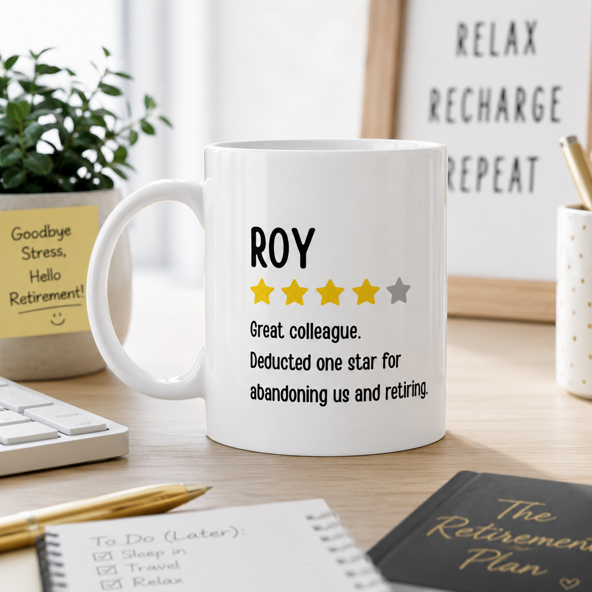 A white ceramic mug printed with the name 'ROY', five stars, and a retirement-themed joke, sitting on a desk in a styled office setting.