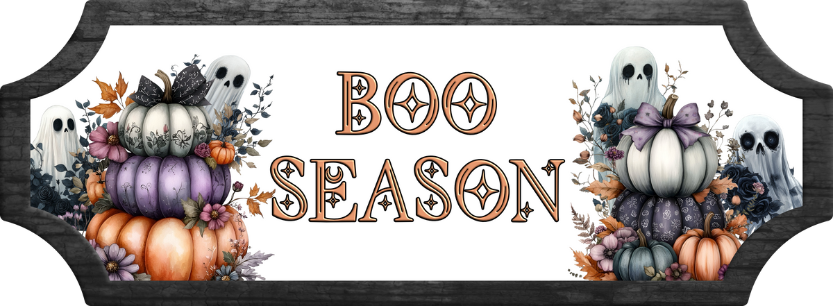 A decorative Halloween sign with the words “BOO SEASON” in large ornate letters, flanked by illustrated pumpkins, ghosts, and autumn foliage. The sign has a dark wood-look border and a white center panel.
