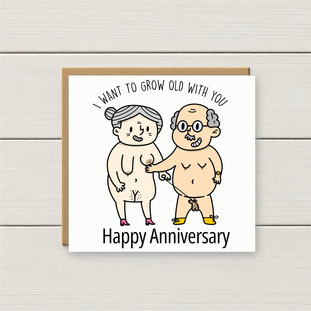 Card with cartoon illustration of an elderly couple and text 'I want to grow old with you. Happy Anniversary' on a wooden surface.