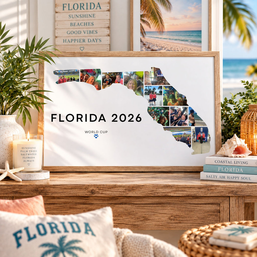 A framed Florida state silhouette print with the text 'FLORIDA 2026' and a collage of photos along the right side, displayed on a wooden console in a styled room with beach-themed decor, pillows, plants, and books.